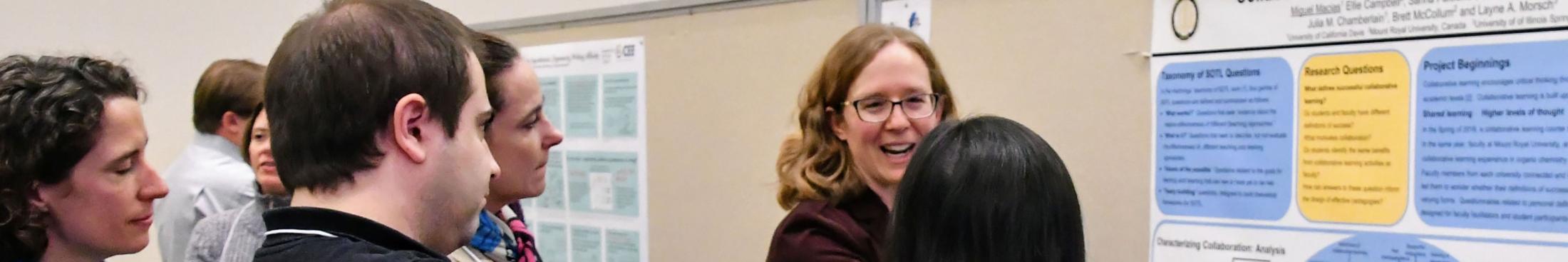 A crowd gathers at a poster during the 2017 SOTL conference.